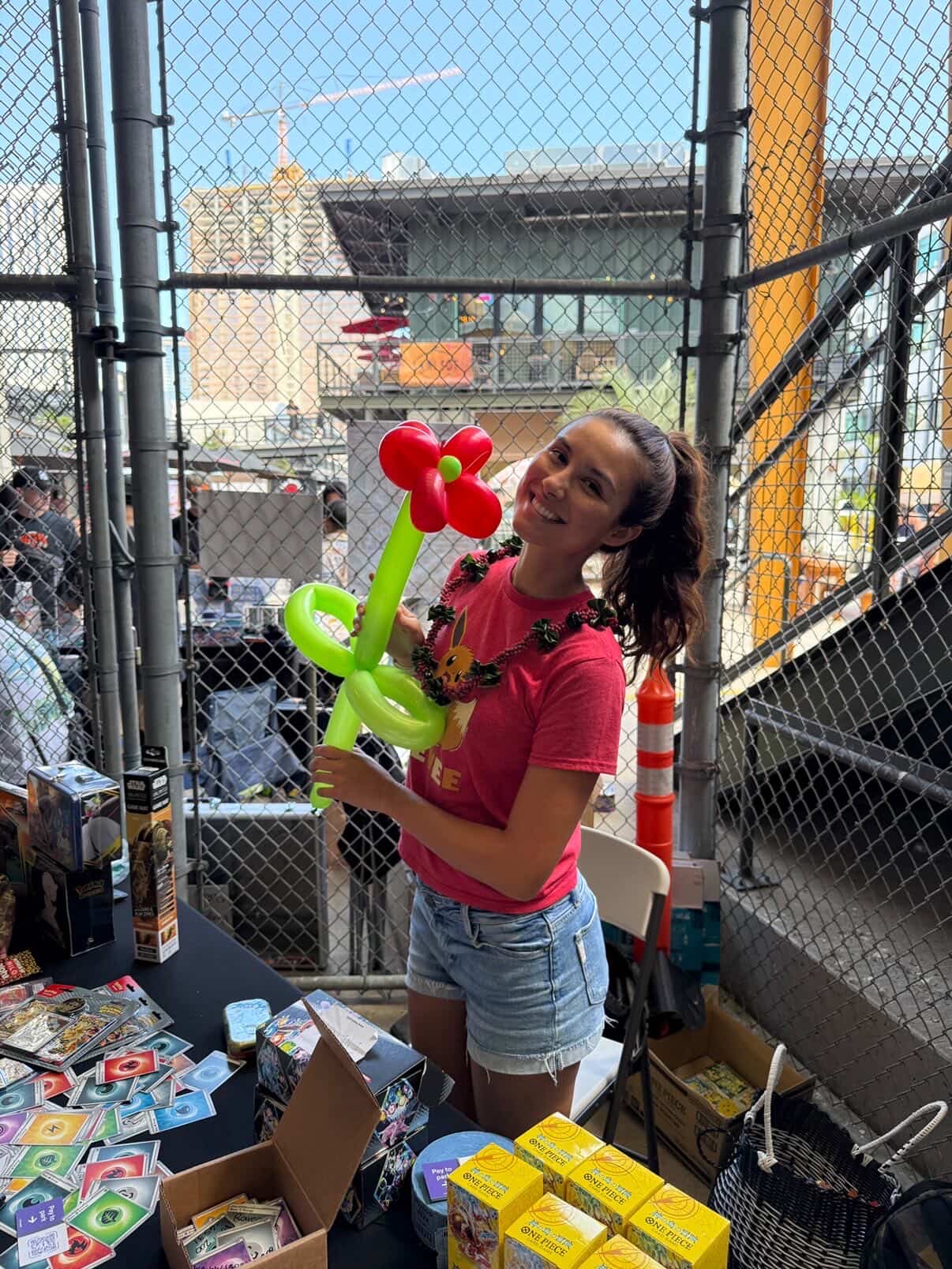 Keep It Aloha Card Show — young attendee with a balloon flower at a vendor table